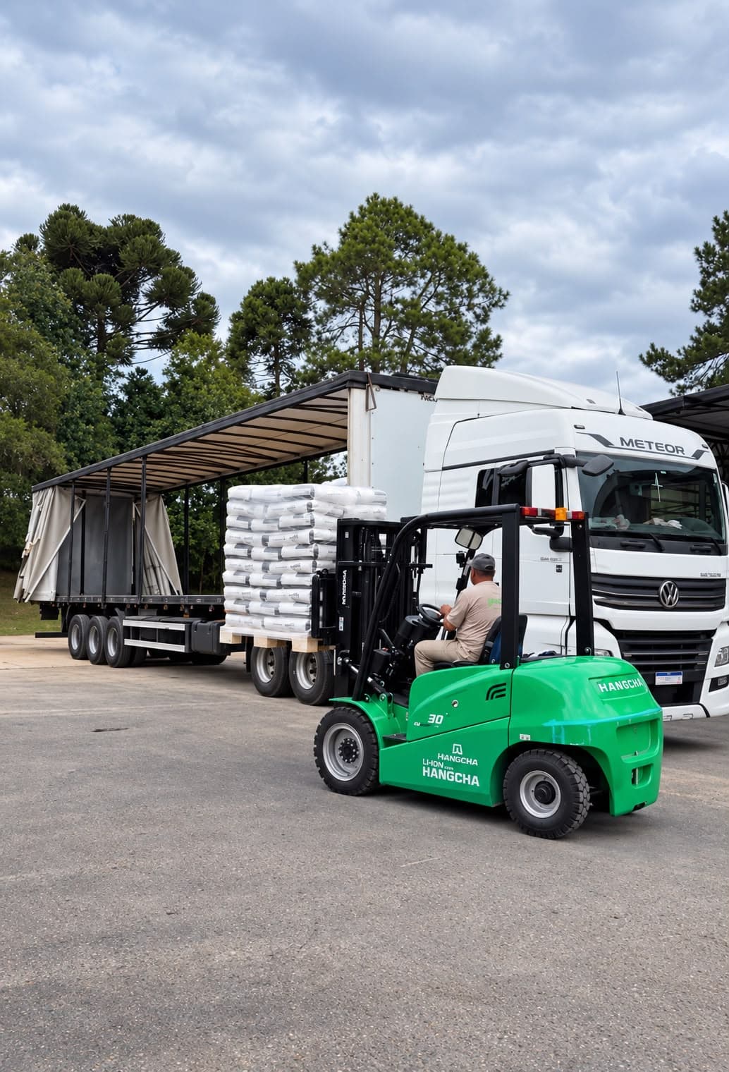 Empilhadeira carregando pallets de sacos de farinha de arroz em uma carreta